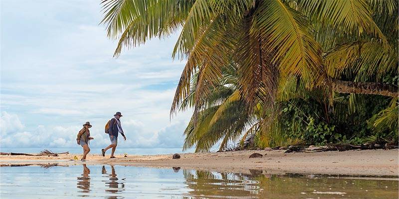 Man and women on beach with palm trees