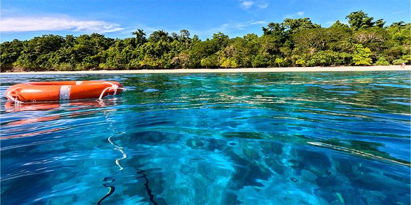 blue clear water with a orange life ring floating on top