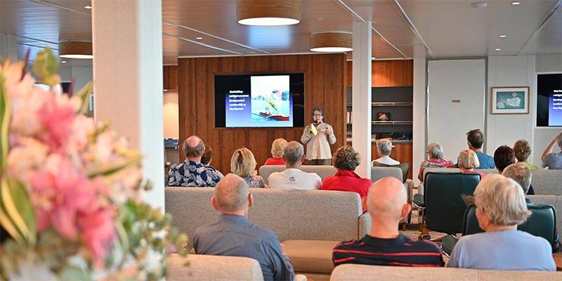 People inside a boat listening to a speaker