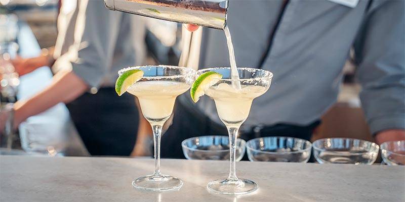 Two cocktails being poured with lime