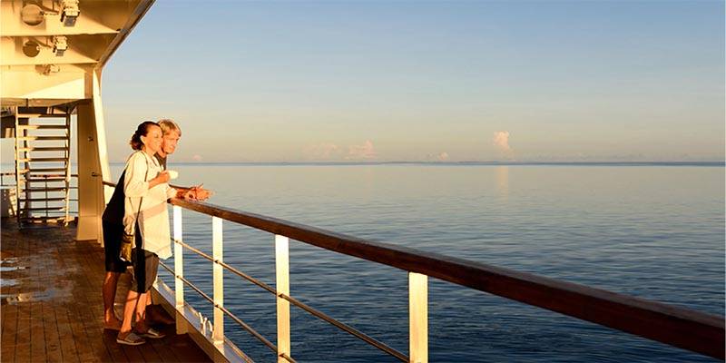 Couple on a boat deck looking out to sea